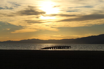 Sunset over the sea and pier silhouette. Photo taken in ören burhaniye aegean sea coast turkey anatolia asia. Fresh air calm warm open weather day in summer 2021.