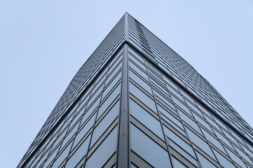 Fototapeta na wymiar Bottom view of the corner of a high-rise glazed building.