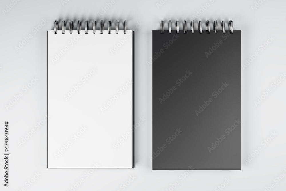 Poster top view and close up of two white and black spring notepads on white desktop background. mock up pl