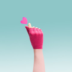 K pop concept. A girl teenager hand with magenta glove showing finger heart gesture. Red heart...