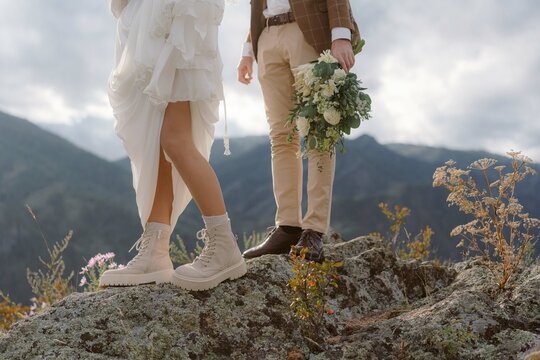 Legs of the bride and groom in wedding dresses
