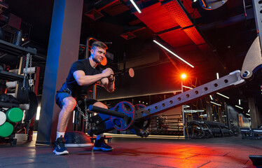 Obraz premium Athletic doing exercises in modern gym. Handsome strong man training in the gym.