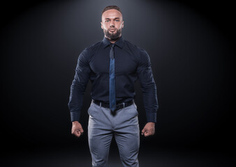 Image of a stylish powerful man in a black shirt and tie. Business and bodybuilding concept. Sports...
