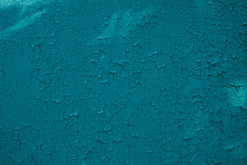 old wall close-up. the wall is painted bright blue, cracked by time and the weather. backdrop for photo