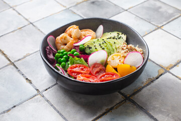 Fresh Avocado, shrimps salad with green pies, cherry tomatoes, herbs and olive oil, lemon dressing. healthy food