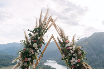 Wedding arch in the shape of a triangle with flowers