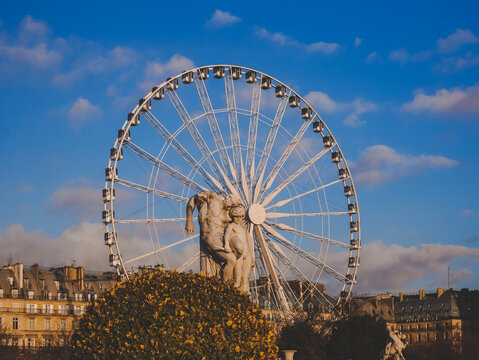 Noria parisina y escultura bajo un cielo azul