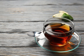 Concept of hot drink with tea on gray wooden background