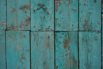 texture of a wooden fence.  fence painted green.  peeling paint on an old fence.  old wood texture.  photo can be used as a photophone, as a texture