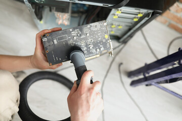 Man mechanic clean computer processor detail with vacuum cleaner nozzle