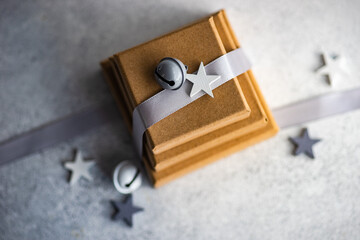 Overhead view of three gift boxes with a ribbon and Christmas bells and star shape decorations