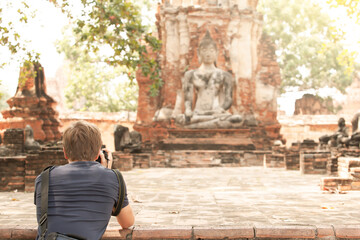 Tourist man taking pictures at an ancient temple.
