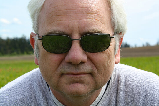 Close-up Portrait of a senior man outdoors wearing sunglasses