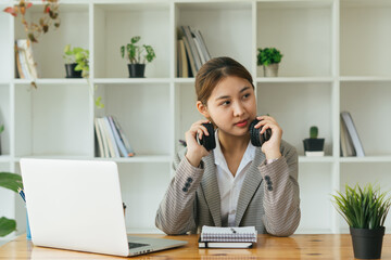 Obraz premium Young woman having online training, using laptop and wireless headset