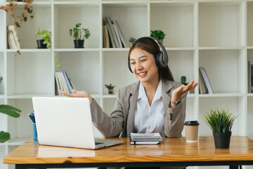 Young woman having online training, using laptop and wireless headset