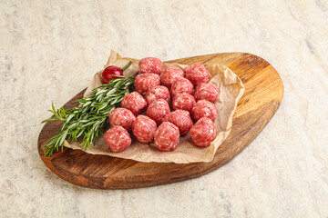 Raw uncooked beef meatballs served rosemary