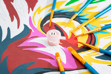 Paint by numbers. Canvas painted with numbered brushes and tempera colors. Concept of recreational...