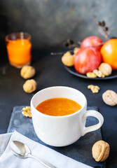 Persimmon fruit smashed in a cup on the dark background