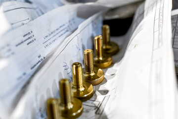 In the workshop in the warehouse, bronze bolts on sheets according to drawings.