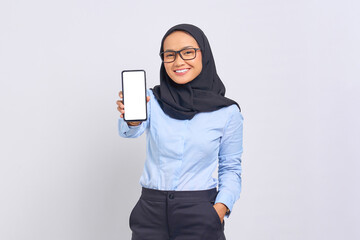 Portrait of smiling young Asian woman showing blank screen mobile phone isolated on white background