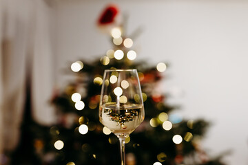 Wine glass in front of a Christmas tree with bokeh 
