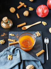 Persimmon fruit smashed in a glass cup with cinnamon and nuts on the dark background