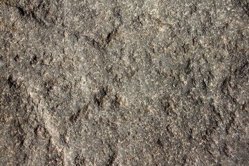 Old structured dry natural stone grey wall surface closeup rough background texture