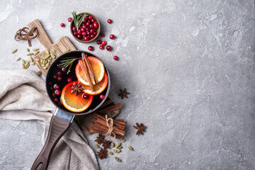Mulled wine with slices of citrus fruits, berries and aromatic spices