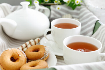 Two cups of hot tea with delicious cookies on  wooden table.