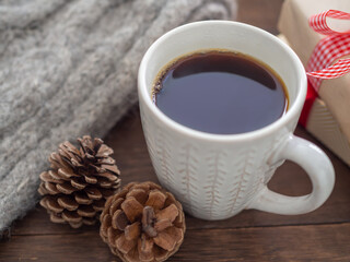 カップに入ったコーヒーと松ぼっくり、プレゼント