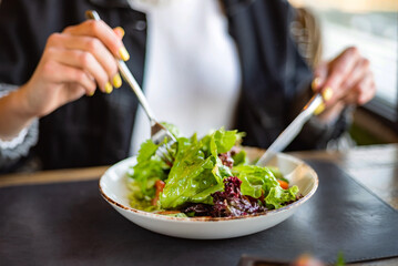 woman eating salad in the restaurant