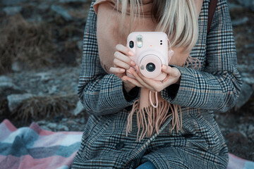 Woman hands holding a pink instax camera