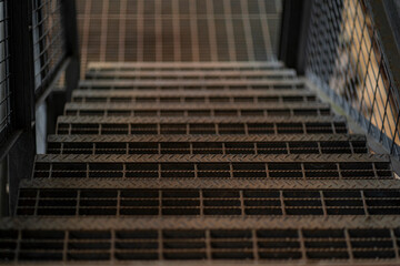 Close up of steel stairs going down under low light. Selective focus points. 