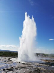 Fototapeta na wymiar geyser expelling water on a blue background