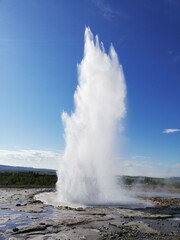 geyser expelling water on a blue background