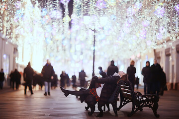 girl christmas lights evening decorated city, a young model on the background of urban decorations and garlands, night city lights