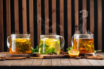 Side view on three glass pots of various hot tea 