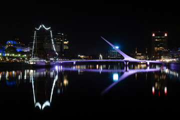 puerto madero buenos aires argentina, reflection in the water of the puente de la mujer and a boat by night