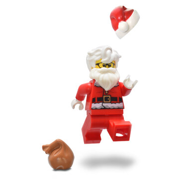 Lego minifigure Santa Claus in red costume with beard and hair is flying high. Editorial illustrative image of holiday christmas.