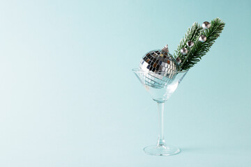 Empty martini glass with disco ball and fir decor, creative christmas party