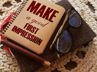Make a Good First Impression written on book cover, eyeglasses and pen. Business career motyvation...