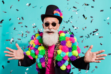Photo of funky impressed mature showman dressed creative pom-pom jacket smiling isolated turquoise...