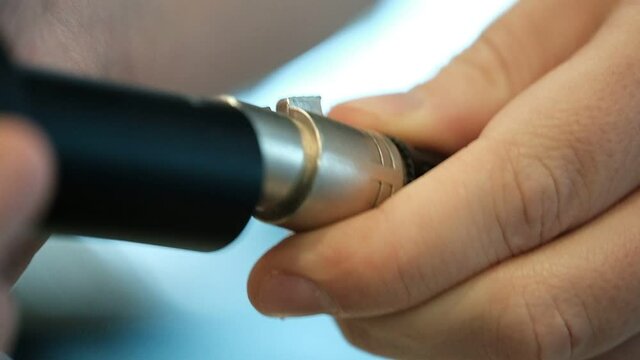 An extreme close up of a microphone connected by a technician to an audio cable. radio station, Israel.