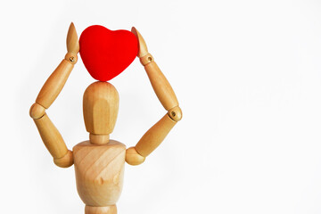 wooden mannequin holding a red heart