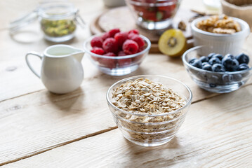 Healthy breakfast concept with oat flakes, fruits, nuts, berries, seeds