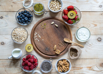 Healthy breakfast concept with oat flakes, fruits, yogurt, nuts, berries, chia seeds