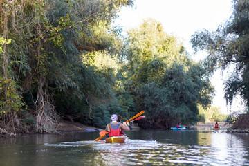 People boating on small river and having fun. Back view