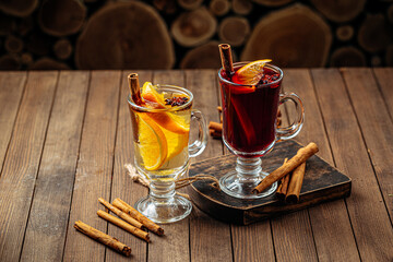 Two glass mugs of mulled wine with spices and orange