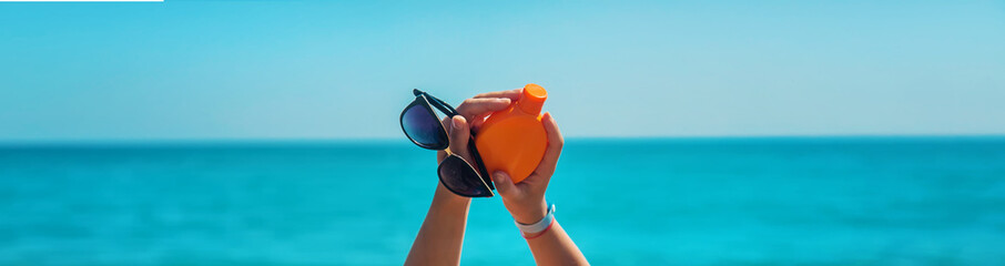 Sunscreen in the hands of a woman. Selective focus.