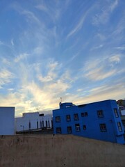 Obraz premium Atardecer con casas y cielo con nubes
